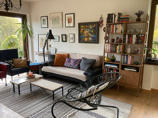 Salon w stylu mid-century z regałem Plywood Project ze sklejki, sofą i dekoracjami na ścianie