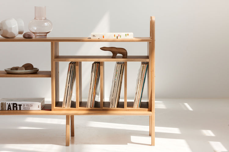 Zbliżenie na przegródki z winylami w komodzie mid-century